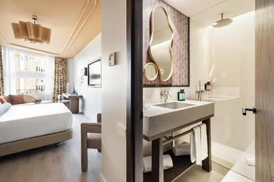 a bathroom with a sink and a bed and a mirror at One Shot Puerta Ruzafa in Valencia