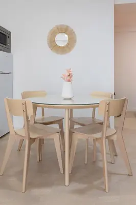 a dining room table and chairs with a vase on it at Apartamentos Sol de Azahar in Valencia