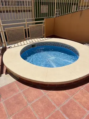 a large circular pool in a patio with a tile floor at Apartment with the pool in Moncófar