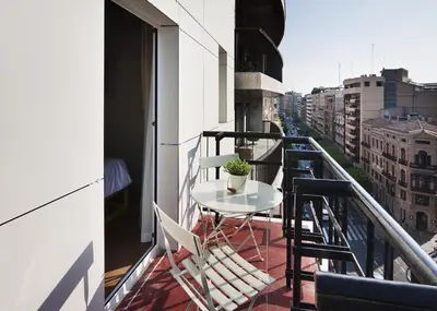 a balcony with a table and chairs on a building at One Shot Colón in Valencia