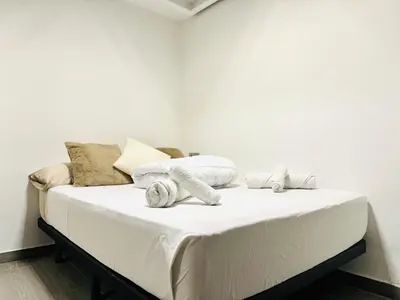 a white bed with towels on it in a room at Suite Palacio Congresos in Valencia