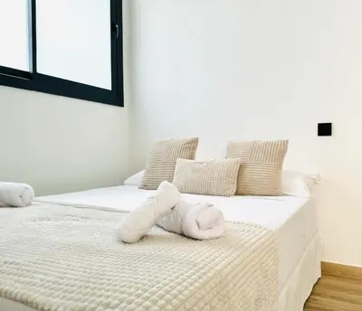 a bedroom with two beds with white towels on them at Suite Palacio Congresos in Valencia
