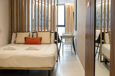 a bedroom with a bed and a table in a room at VLC HOST - Palleter in Valencia