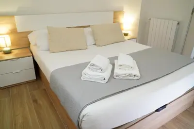 a bedroom with a large white bed with towels on it at Casa Dolce Casa - Elegant 3BR Apartment Near Metro & Beach,Valencia in Valencia