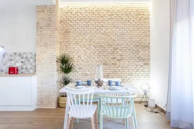 a white table and chairs in a room with a brick wall at new apartment 4 pax front central station wifi in Valencia