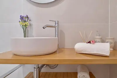 a bathroom sink on a wooden counter with flowers at Romantic Suite Roig Arena N10 Virkin Suites in Valencia