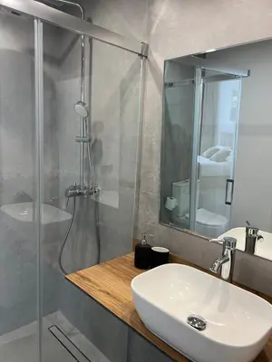 a bathroom with a white sink and a shower at Mistral Suites in Valencia