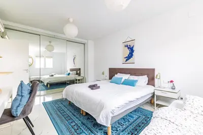 a white bedroom with a large bed and a mirror at Casa Familiar 9 Pax, Smart TV, Centro, Playa, Café, AC in Valencia