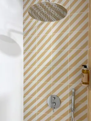 a shower with aige and white striped wall at Exclusive beachfront apartment in Valencia