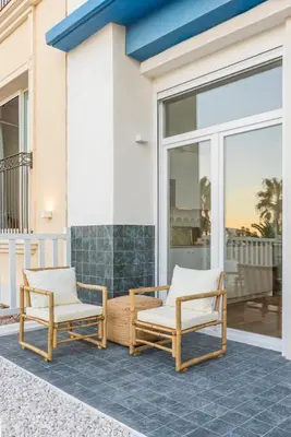 two chairs on the front porch of a house at Exclusive beachfront apartment in Valencia