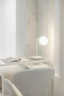 a white desk with a lamp and a white chair at Exclusive beachfront apartment in Valencia
