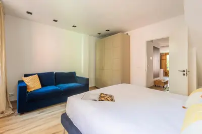 a bedroom with a bed and a blue couch at Luxury new apartment 10 min walk to the beach, Late Checkout in Valencia