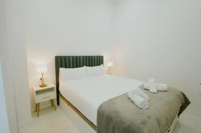a bedroom with a large white bed and a night stand at Apartment 1 City of Arts and science Fast Wifi 1 in Valencia