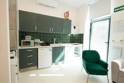 a kitchen with green cabinets and a green chair at Apartment 1 City of Arts and science Fast Wifi 1 in Valencia