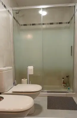 a bathroom with a toilet and a glass shower at La Luz de Lucia in Moncófar