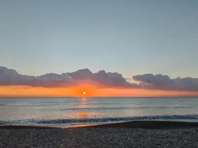 a sunset on the beach with the sun setting at La Luz de Lucia in Moncófar