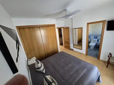 a bedroom with a bed and a bathroom at Relax en familia junto al mar Les Palmeres in Sueca