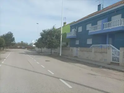 an empty street in front of a blue building at Relax en familia junto al mar Les Palmeres in Sueca