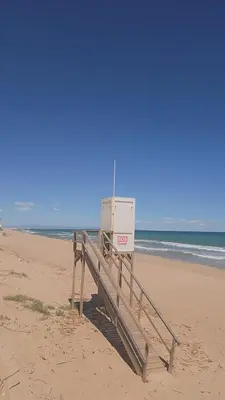 a lifeguard station on a beach with the ocean at Relax en familia junto al mar Les Palmeres in Sueca