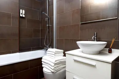 a bathroom with a sink and a toilet and a tub at Grand Central Market Suites By VALENCIAFLATS EU in Valencia