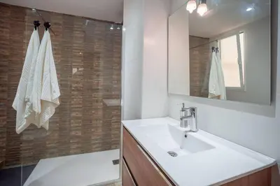 a bathroom with a sink and a mirror and a shower at El Pilar Luxury Suites By VALENCIAFLATS EU in Valencia