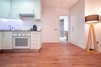 a kitchen with white cabinets and a floor at El Pilar Luxury Suites By VALENCIAFLATS EU in Valencia