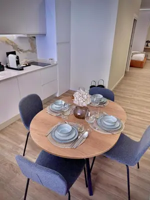 a dining room table with blue chairs and plates at Tao Suite 1 next to the Aquarium in Valencia