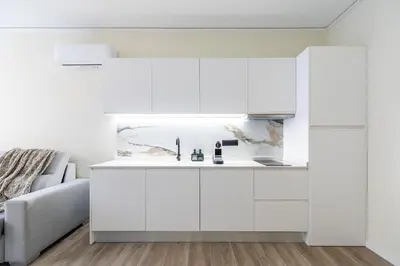 a kitchen with white cabinets and a couch at Tao Suite 1 next to the Aquarium in Valencia