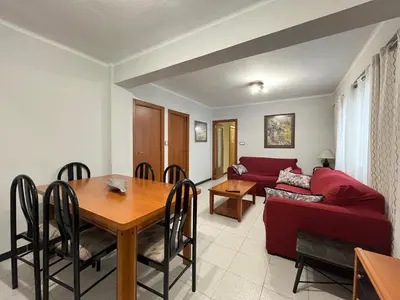 a living room with a table and a red couch at Apartamento Torres Serranos in Valencia