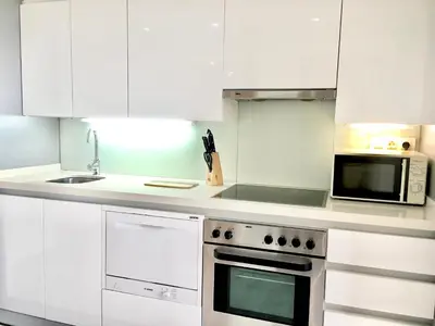a white kitchen with a stove and a microwave at Panoramic Suites By VALENCIAFLATS EU in Valencia