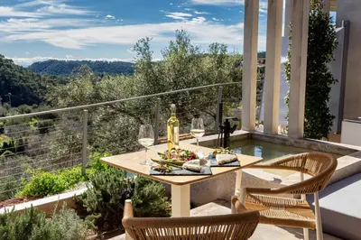 a table with glasses of wine on a balcony at Resort Serra Nature - Luxury Villas Hotel Boutique in Serra
