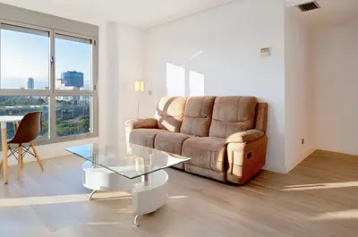 a living room with a couch and a glass table at Resort & Suites Ciudad de las Ciencias By VALENCIAFLATS EU in Valencia