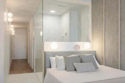 a bedroom with a white bed and a mirror at Designer apartment facing the sea in Valencia