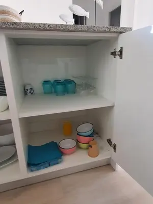 a white shelf with bowls and bowls on it at Edificio JUNIOR in Cullera