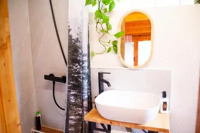 a bathroom with a white sink and a mirror at Cabaña madera en bosque 100 ECO in Petrés