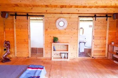 a room with a wooden wall with a bed in it at Cabaña madera en bosque 100 ECO in Petrés