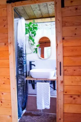 a bathroom with a sink in a tiny house at Cabaña madera en bosque 100 ECO in Petrés