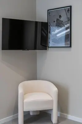a white chair in a room with a tv at VLC Host - Sumsi in Valencia