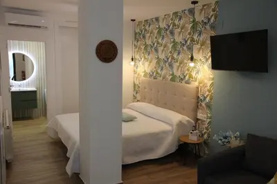 a bedroom with a bed and a couch and a mirror at Ruzafa Acquamarina in Valencia