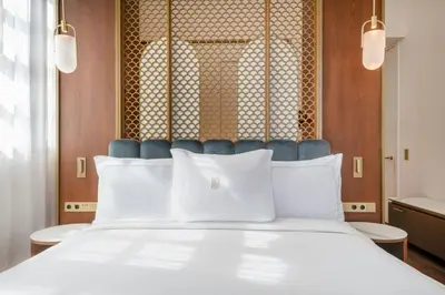 a bedroom with a white bed and a shower at Grand Hotel Centenari, Valencia, Autograph Collection in Valencia
