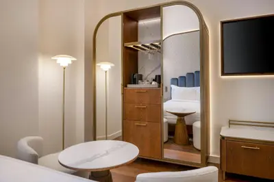 a room with two chairs and a table and a tv at Grand Hotel Centenari, Valencia, Autograph Collection in Valencia