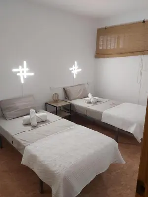 three beds in a room with crosses on the wall at Apartamento amanecer paseo marítimo in Cullera