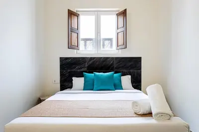 a bedroom with a large bed with blue pillows at The Port Urban Loft in Valencia