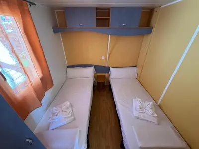 a small room with two beds and a window at Camping Los Naranjos in Moncófar