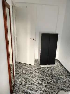 a room with a white wall and a black cabinet at Calle platano37 in Valencia