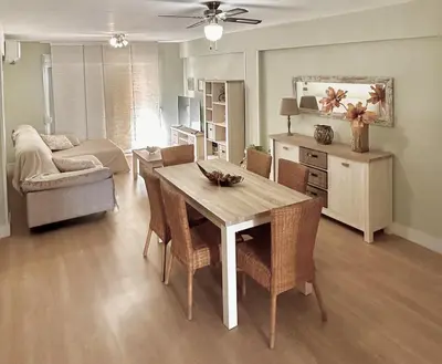 a living room with a table and chairs and a couch at Apartamento Bahía Cullera I in Cullera