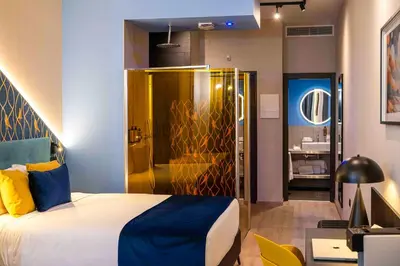 a bedroom with a bed and a shower in a room at Hotel Pathos by Mimood Aparthotels in Valencia