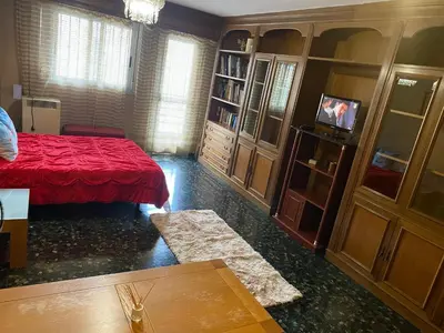 a living room with a red bed and a tv at Habitación central en piso compartido en valencia in Valencia