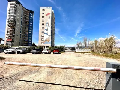 a parking lot with cars parked in front of a building at Vistas al mar, El Puig in El Puig