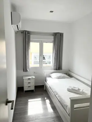 a white bedroom with a bed and a window at Cullera Sea and Mountain Balcony in Cullera